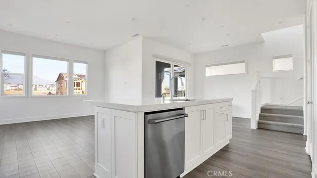 a view of kitchen with stainless steel appliances wooden floor and chair