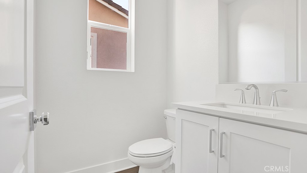 401 Junco Irvine, CA 92618 - Photo 26 of 40 a bathroom with a granite countertop sink toilet and a mirror