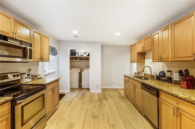 a kitchen with a sink a stove cabinets and wooden floor