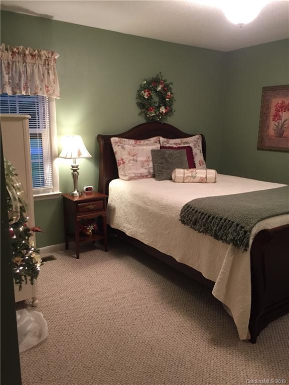 181 Sunset Drive, Unit 18A Rutherfordton, NC 28139 - Photo 9 of 10 a bed sitting in a bedroom next to a lamp