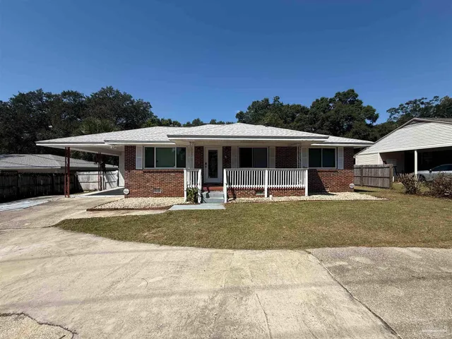 a view of a house with a garden and sitting area