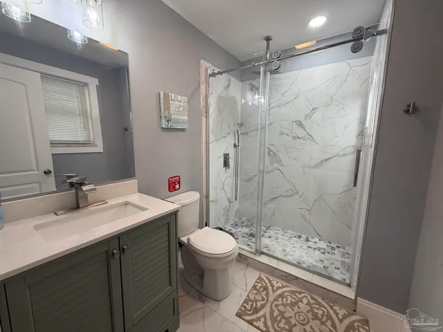 a bathroom with a sink toilet vanity and shower