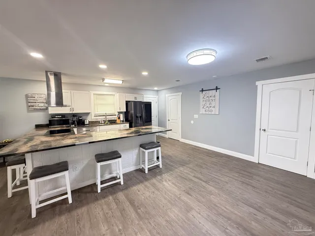 a kitchen with a sink cabinets and wooden floor