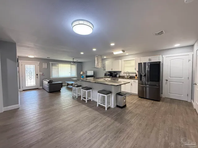 a kitchen with a sink appliances and wooden floor