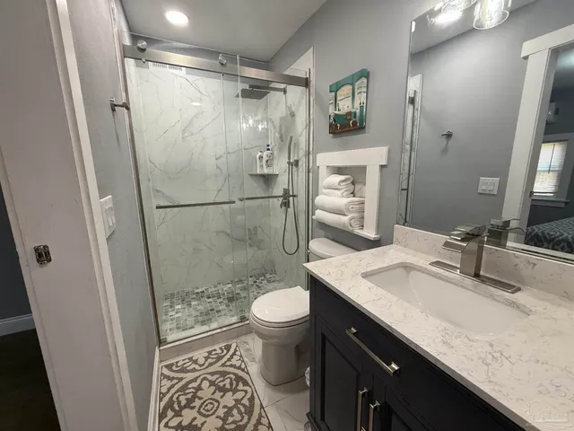 a bathroom with a granite countertop sink toilet and shower