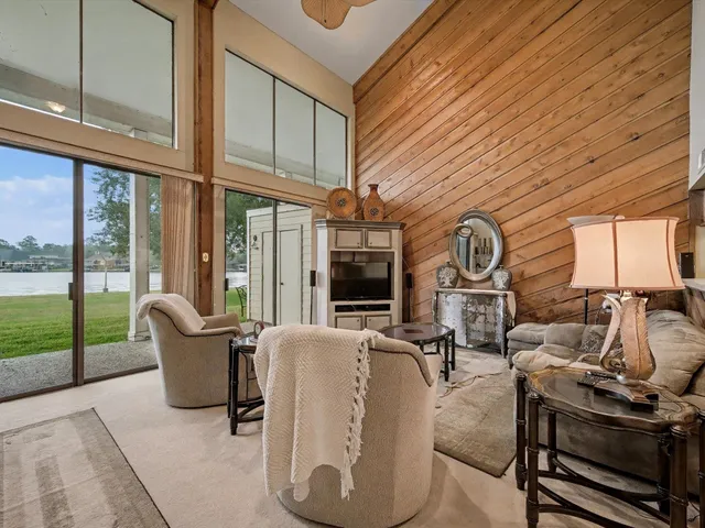a living room with furniture a fireplace and large windows