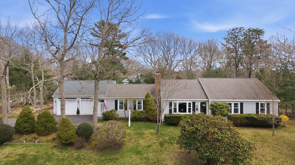 a aerial view of a house next to a big yard and large trees