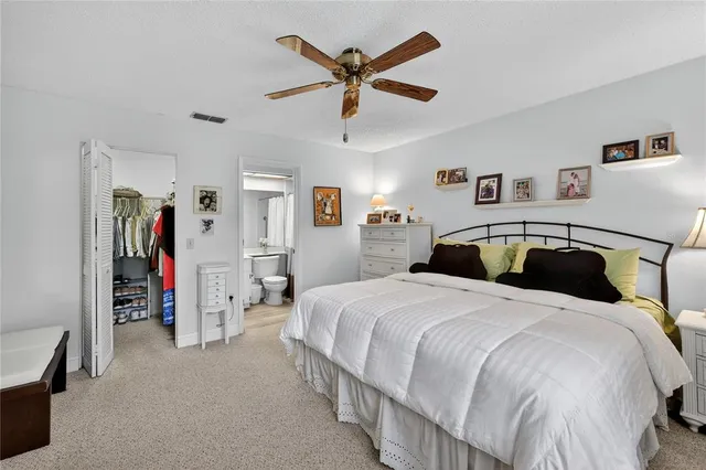a spacious bedroom with a bed and ceiling fan