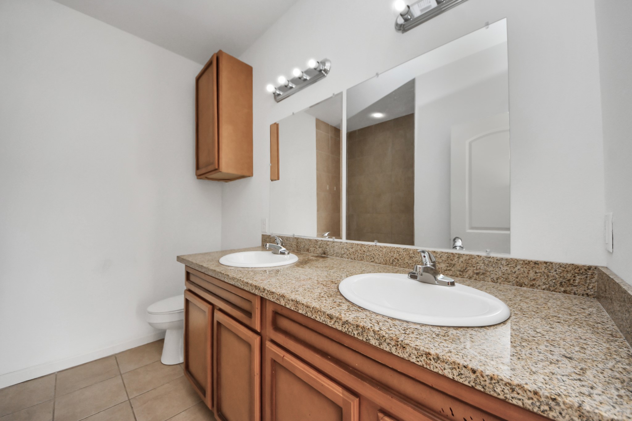 4334 Oak Ridge Drive, Unit A Pasadena, TX 77503 - Photo 11 of 20 a bathroom with a granite countertop sink a toilet and mirror
