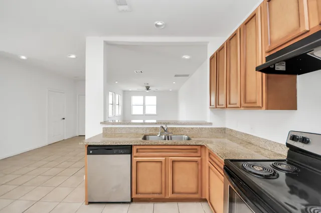 a kitchen with stainless steel appliances granite countertop a sink stove and cabinets