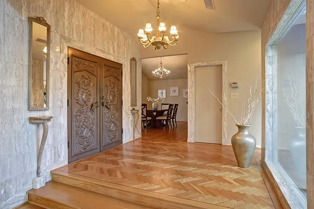a view of a hallway with a livingroom and a chandelier