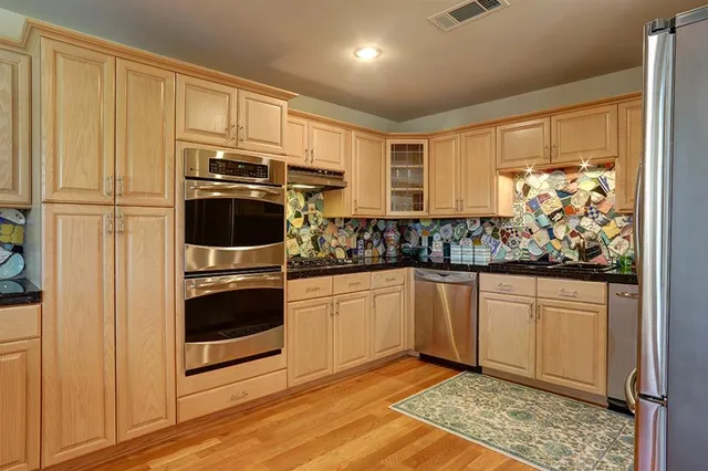 a kitchen with stainless steel appliances granite countertop a refrigerator and a sink