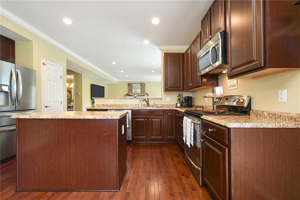 179 Broadstone Drive Mars, PA 16046 - Photo 11 of 25 a kitchen with stainless steel appliances granite countertop a stove top oven a sink dishwasher a refrigerator and cabinets with wooden floor