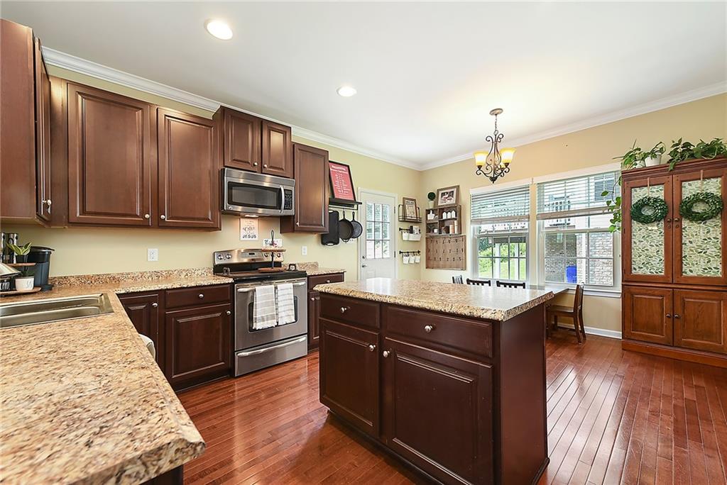 179 Broadstone Drive Mars, PA 16046 - Photo 9 of 25 a kitchen with stainless steel appliances granite countertop a stove a sink dishwasher and a refrigerator with wooden floor