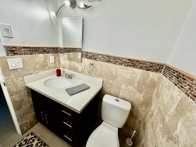 a bathroom with a sink vanity mirror and toilet
