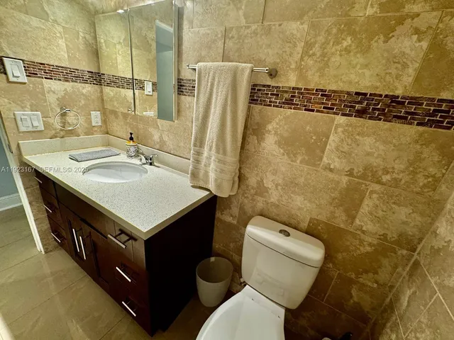 a bathroom with a sink and mirror with toilet