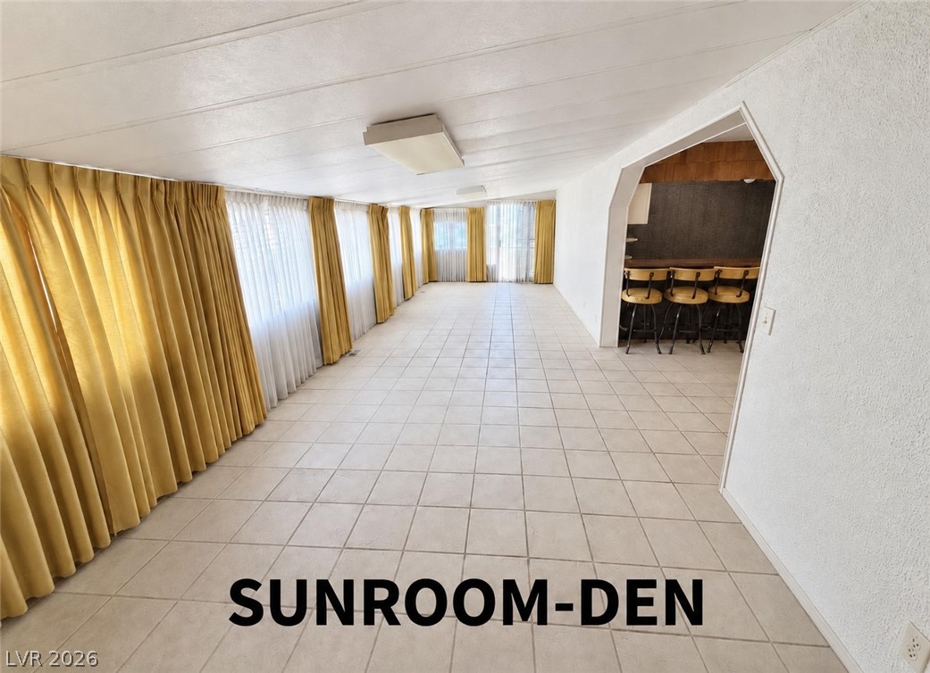 4556 Royal Ridge Way Las Vegas, NV 89103 - Photo 10 of 49 Tiled flooring runs the length of this elongated space lined with extensive windows.