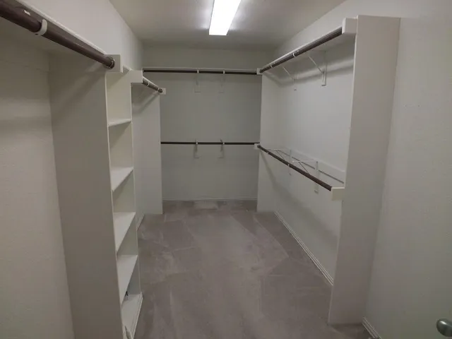 a view of walk in closet with empty racks