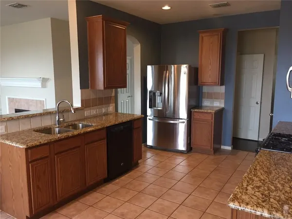 a kitchen with stainless steel appliances granite countertop a refrigerator and a sink