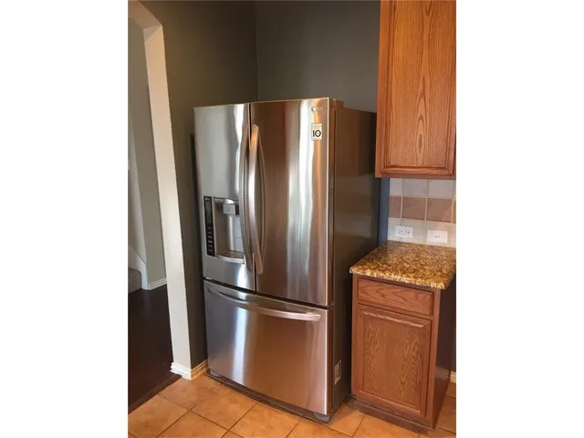 a metallic refrigerator freezer sitting in a kitchen