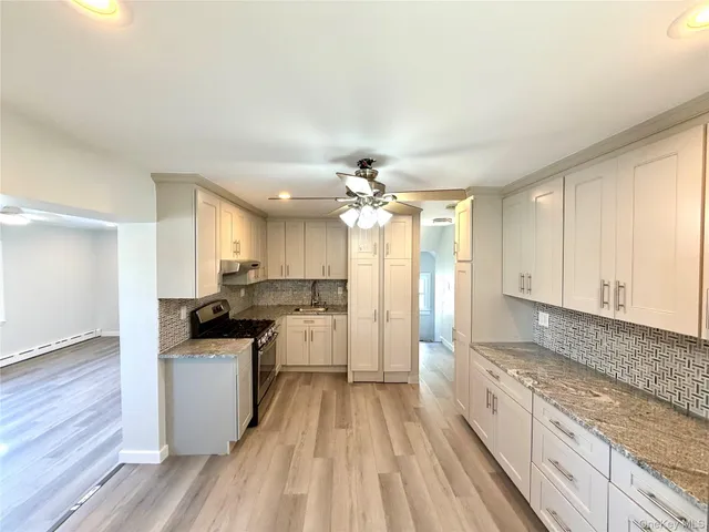a kitchen with a sink a counter top space stainless steel appliances and cabinets