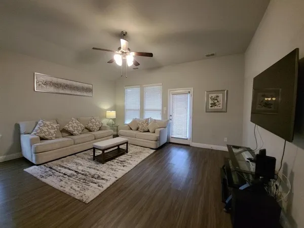 a living room with furniture and wooden floor