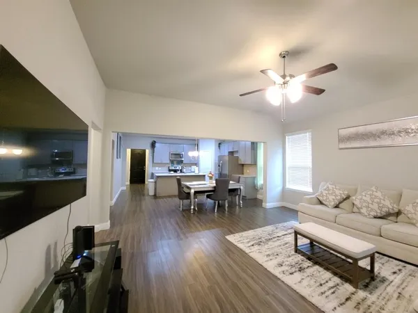 a living room with furniture and view of kitchen