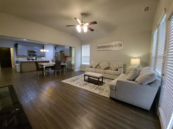 a living room with furniture and a wooden floor
