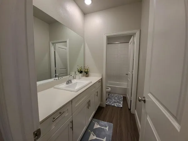 a bathroom with a sink a toilet a shower and a mirror