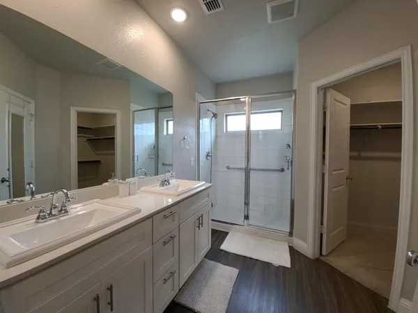 a spacious bathroom with a double vanity sink a large mirror a shower and a bathtub
