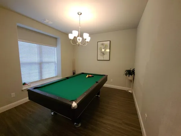 a room with pool table and windows