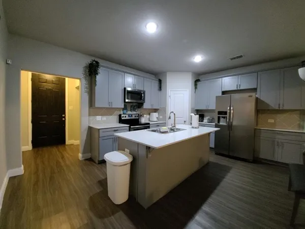 a kitchen with a sink appliances and cabinets