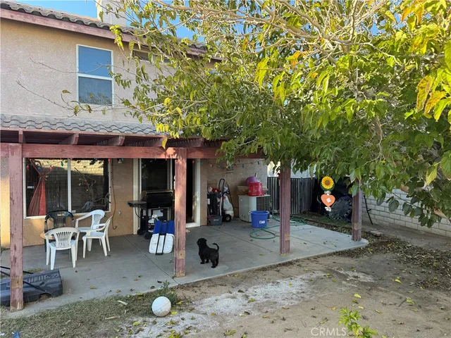 a backyard of a house with barbeque oven table and chairs