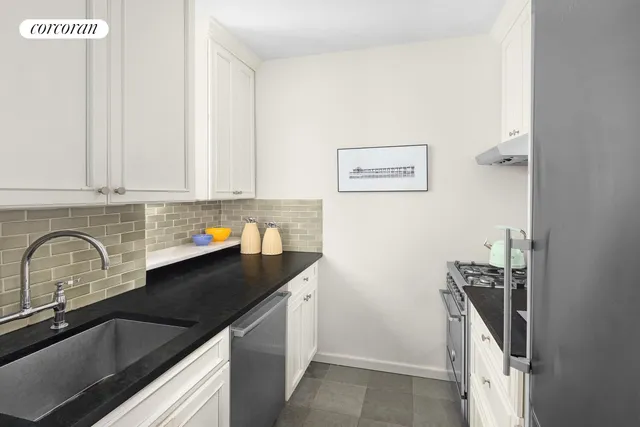 a close view of a sink a counter and cabinets in the kitchen