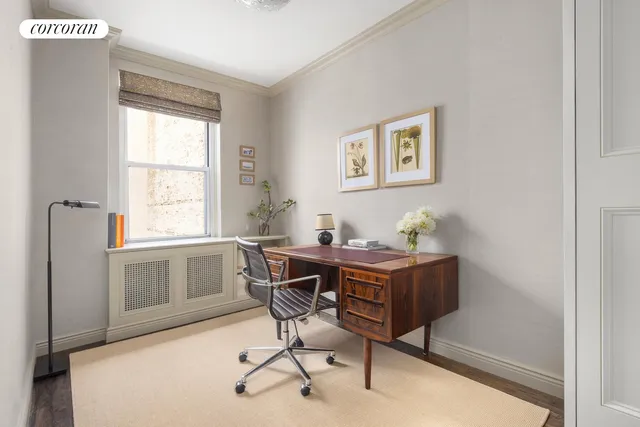 a view of a workspace with furniture and a window