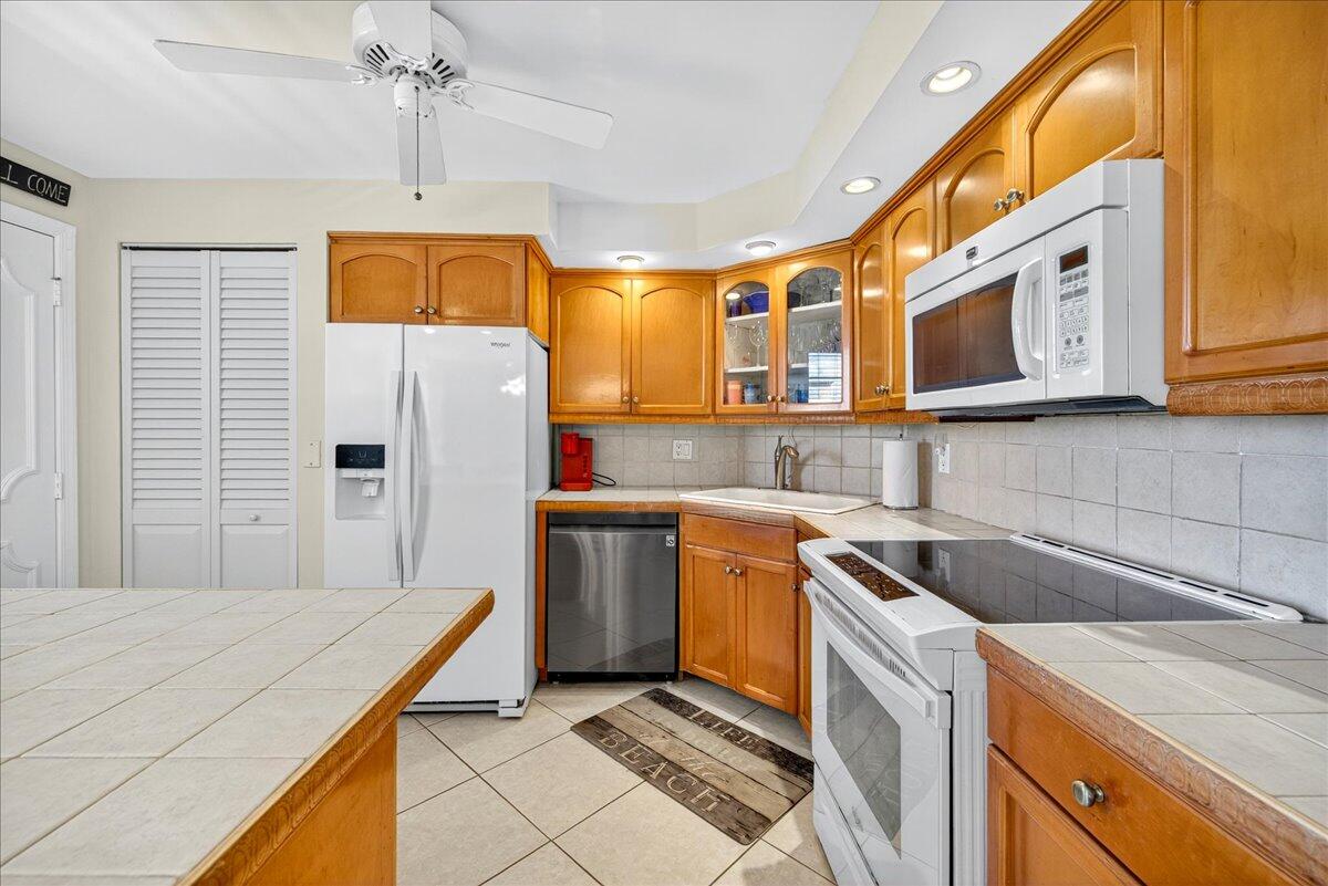 1 Harbourside Drive, Unit 3505 Delray Beach, FL 33483 - Photo 9 of 38 a kitchen with stainless steel appliances granite countertop a sink a refrigerator and a stove