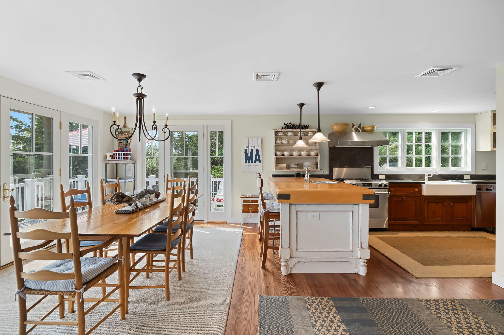 63 Briar Spring Road Orleans, MA 02653 - Photo 10 of 37 a living room with a dining table a rug couches and a dining table with wooden floor
