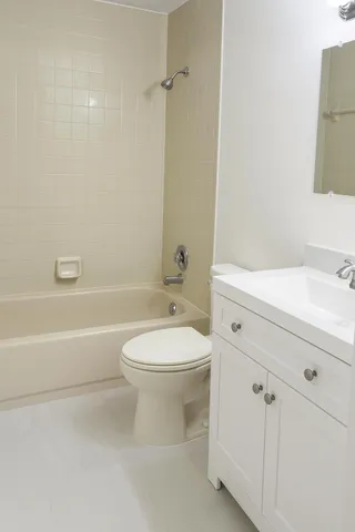 a bathroom with a toilet a sink a mirror and vanity