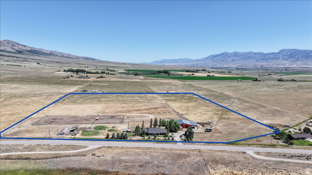 1634 West Arimo Road Arimo, ID 83214 - Photo 84 of 89 Expansive rural property featuring a main residence, a prominent red barn, multiple outbuildings, and a large fenced paddock