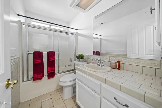 a bathroom with a double vanity sink mirror and toilet
