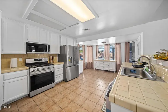 a kitchen with stainless steel appliances granite countertop a stove refrigerator sink and dishwasher