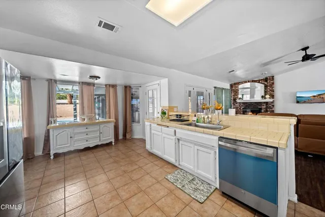 a large white kitchen with cabinets and a large window