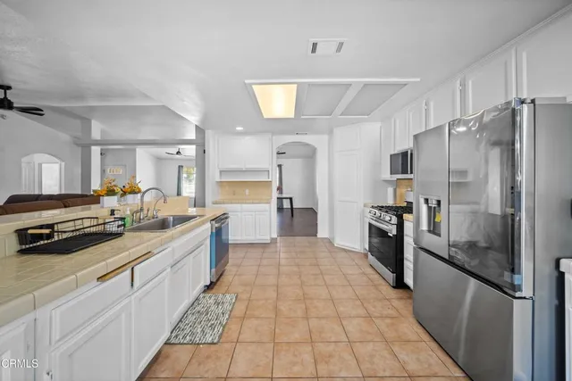 a large kitchen with a large counter top stainless steel appliances and cabinets