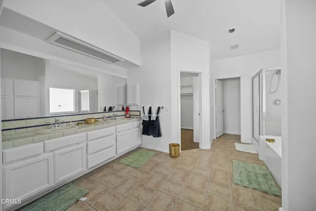 a large white bathroom with a granite countertop sink and a mirror