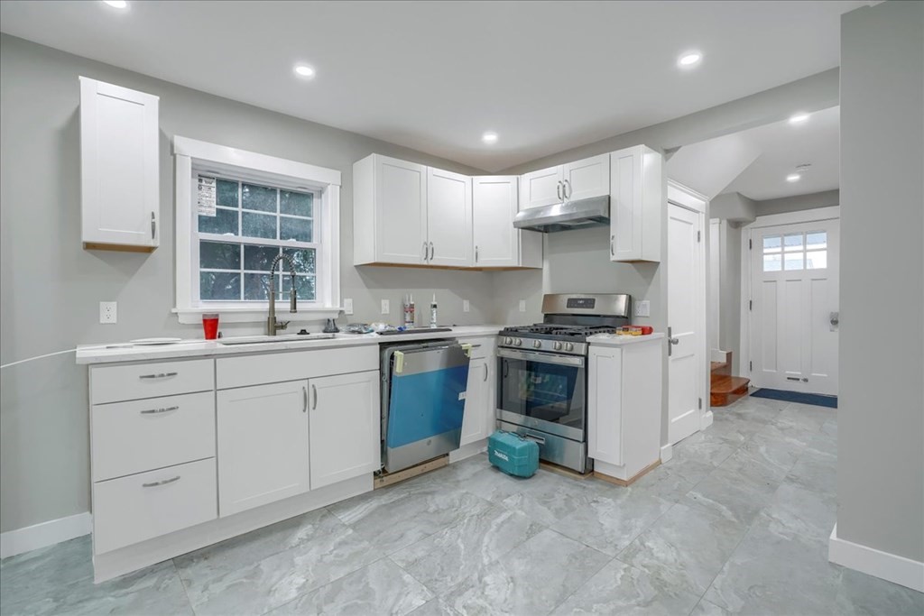 25 Patterson Street Boston, MA 02124 - Photo 12 of 32 a kitchen with granite countertop a sink cabinets stainless steel appliances and a window