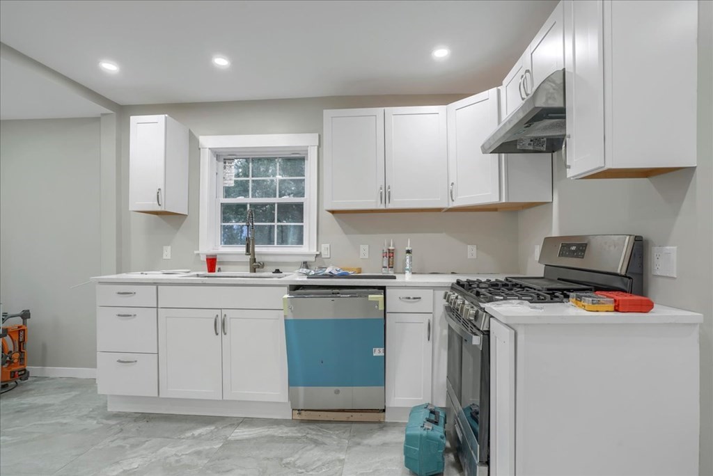 25 Patterson Street Boston, MA 02124 - Photo 13 of 32 a kitchen with stainless steel appliances granite countertop a sink stove and cabinets