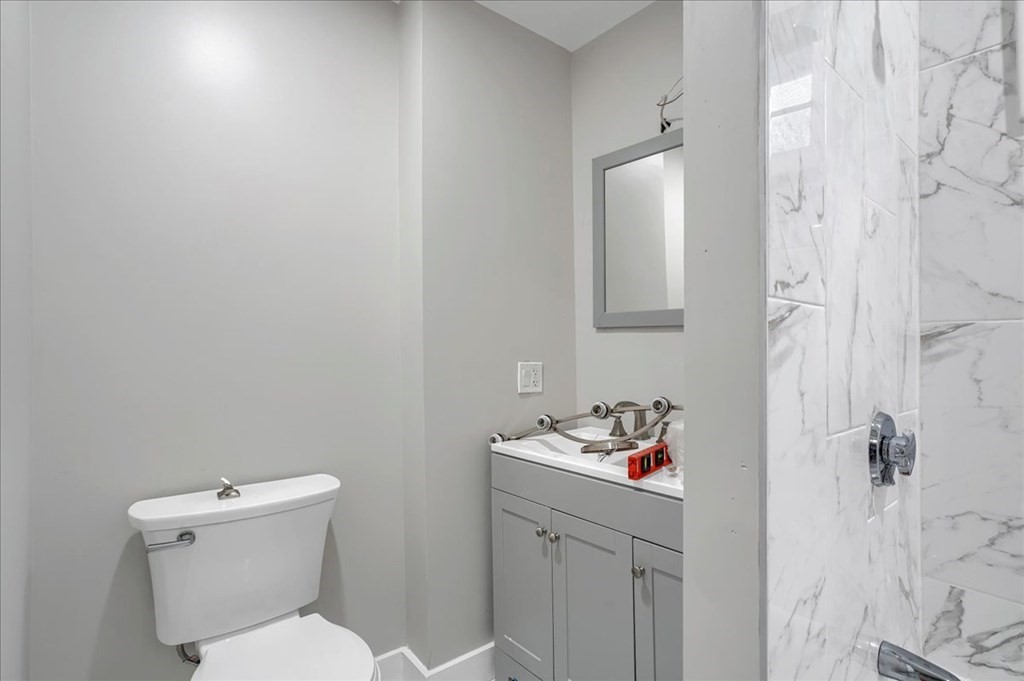 25 Patterson Street Boston, MA 02124 - Photo 18 of 32 a bathroom with a toilet sink vanity and mirror
