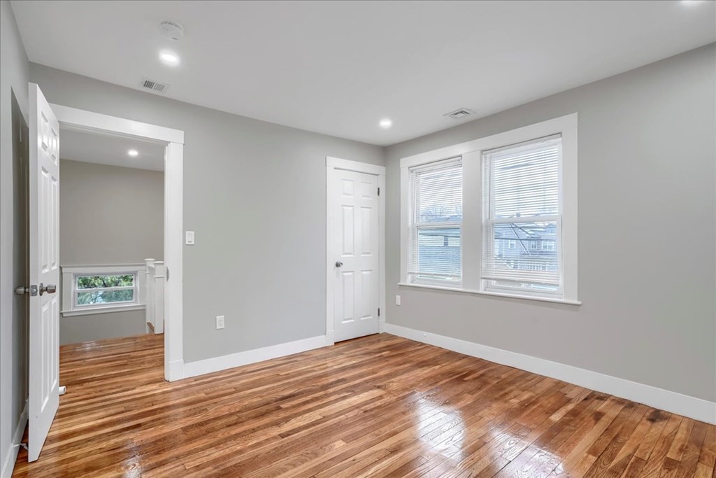 25 Patterson Street Boston, MA 02124 - Photo 19 of 32 en empty room with wooden floor and windows