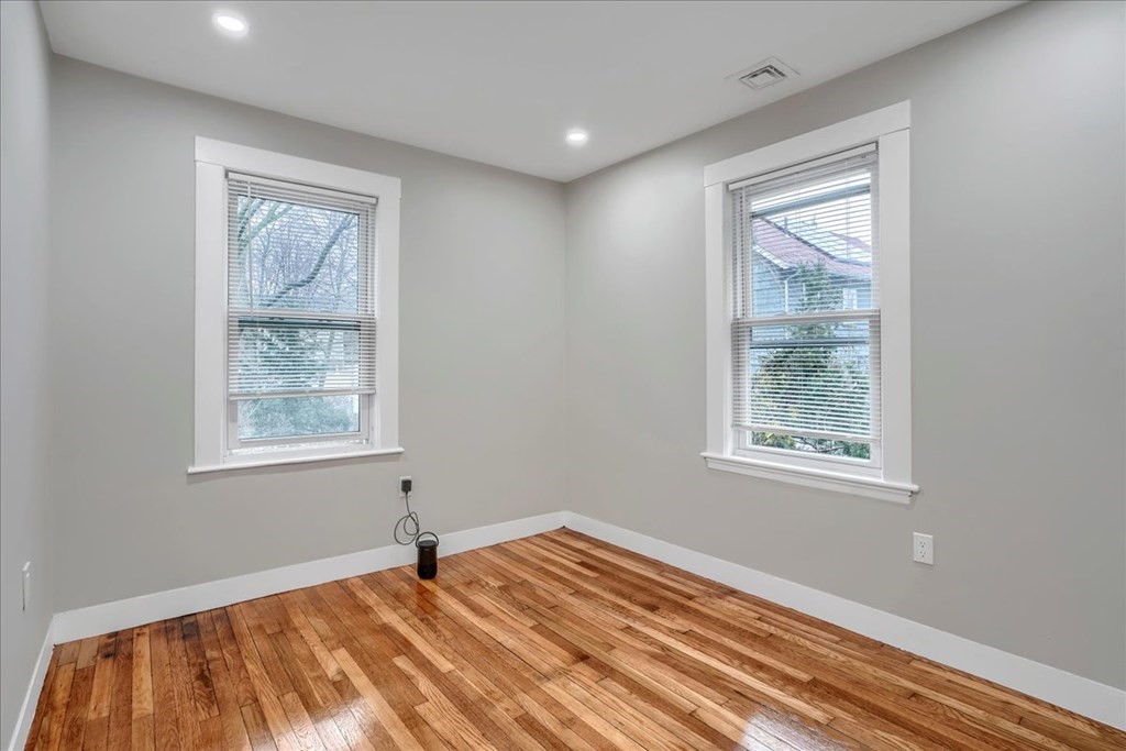 25 Patterson Street Boston, MA 02124 - Photo 26 of 32 a view of an empty room with wooden floor and a window