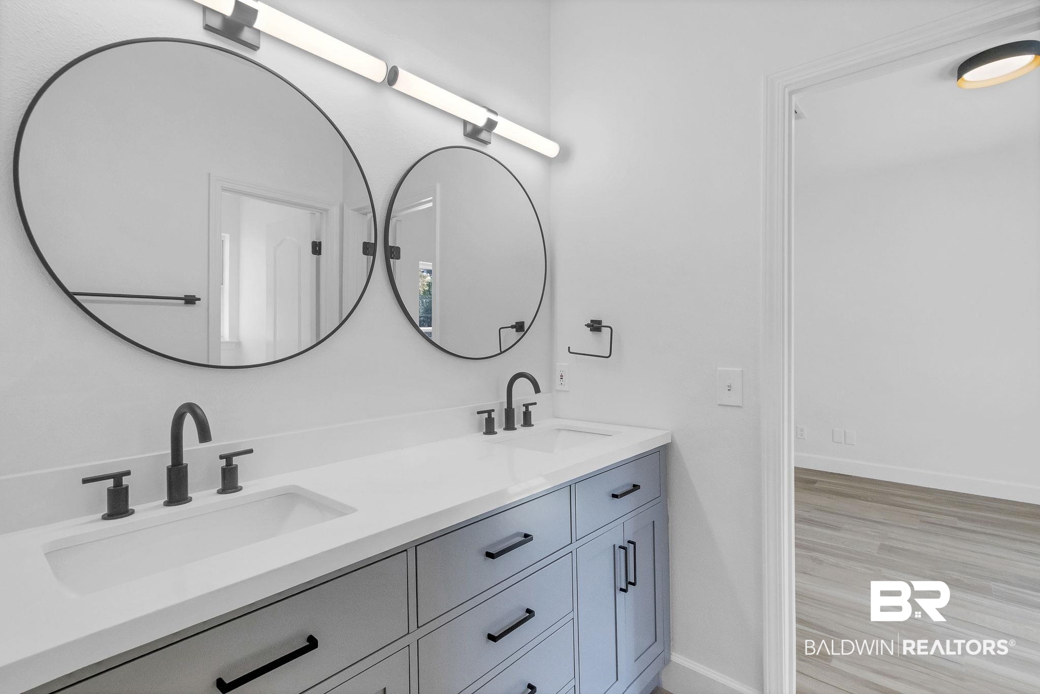 20265 Erin Pond Road Seminole, AL 36574 - Photo 33 of 97 Full bathroom featuring baseboards, double vanity, a sink, and wood finished floors